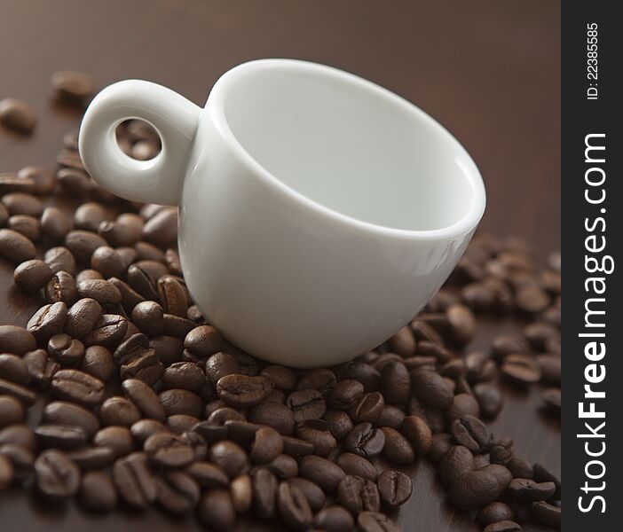 White cup on the coffee beans background. White cup on the coffee beans background