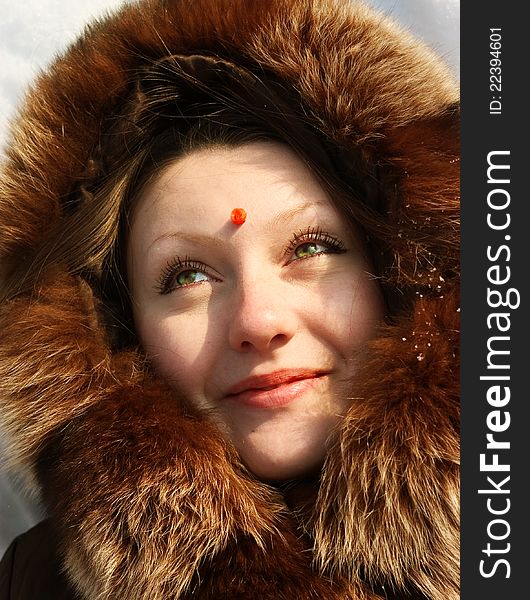 Girl lying in snow with berry of mountain ash on  forehead. Girl lying in snow with berry of mountain ash on  forehead