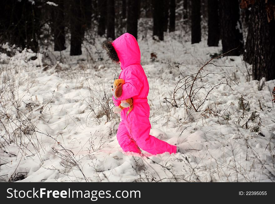 A kid with pink snow suit walking on snow. A kid with pink snow suit walking on snow
