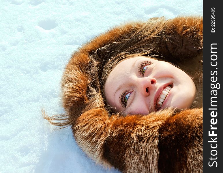 Young laughing woman lies on snow. Young laughing woman lies on snow