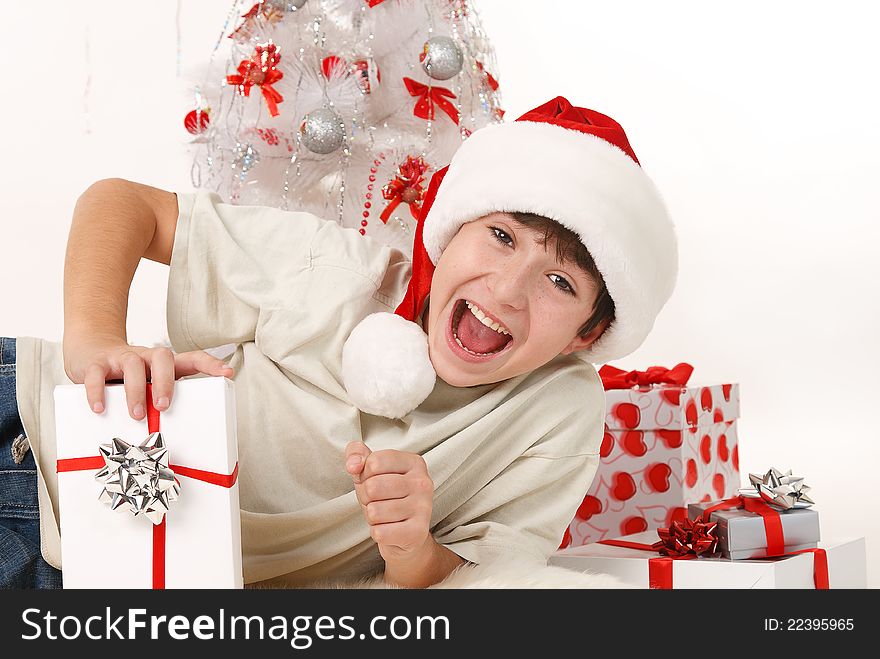 Cheerful child with Christmas gifts and a Christmas tree on a white background