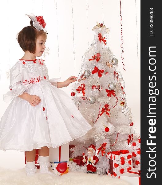 Little girl standing near a Christmas tree