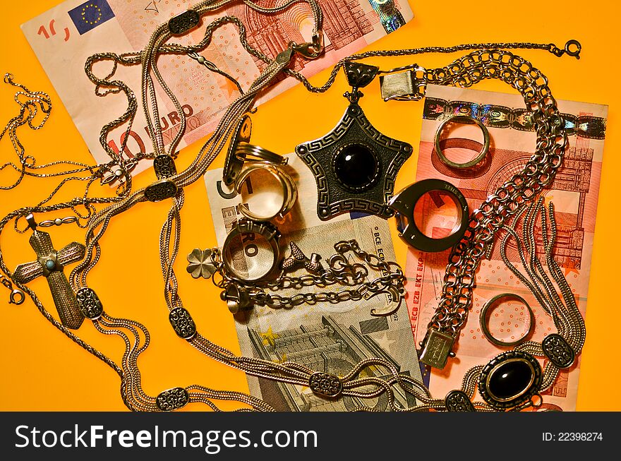 Jewelry and money on yellow background.