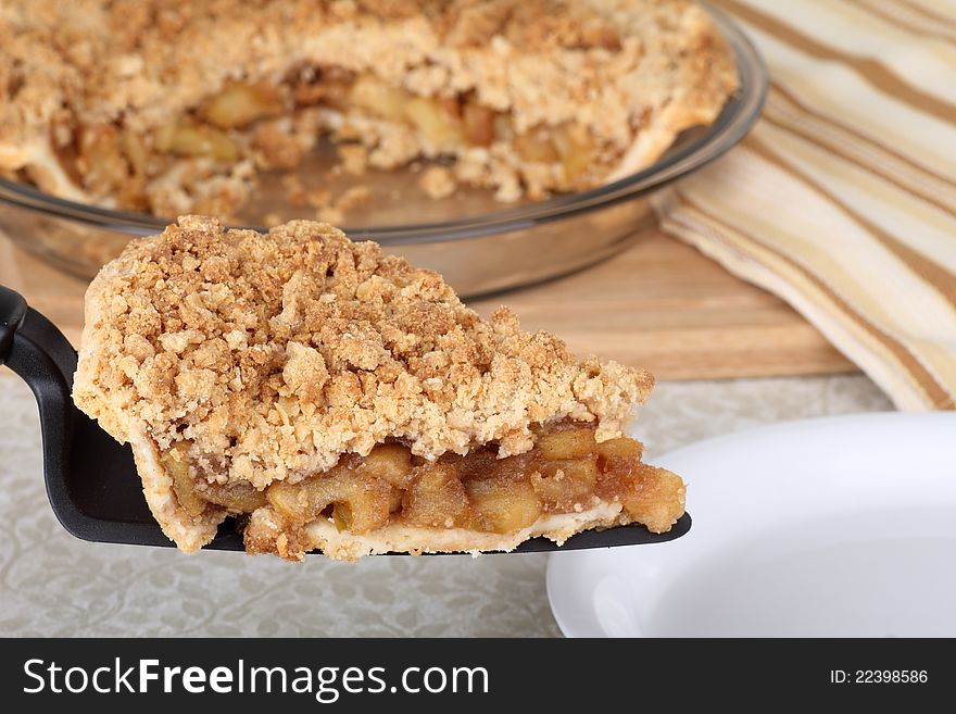 Slice of apple crumb pie on a pie server. Slice of apple crumb pie on a pie server