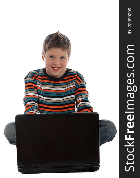 Boy sitting using a laptop computer. Boy sitting using a laptop computer