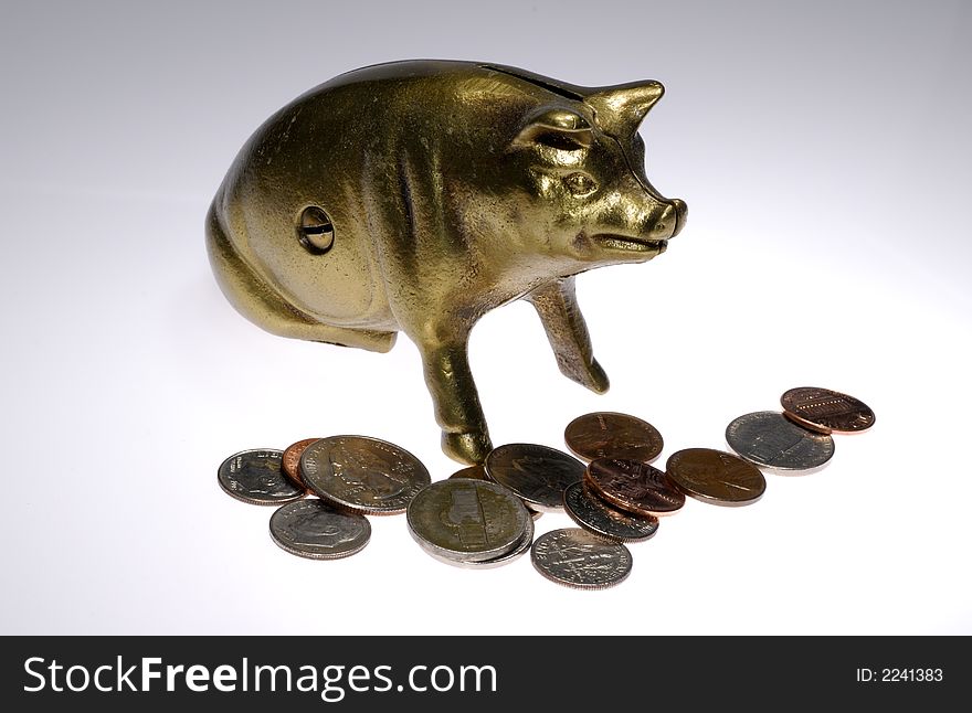 Photo of a Brass Piggy Bank and Coins - Money Related. Photo of a Brass Piggy Bank and Coins - Money Related