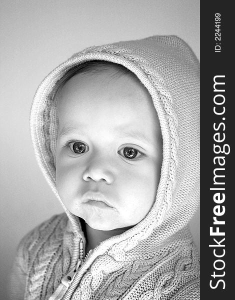 Black and white image of cute baby wearing a hooded sweater. Black and white image of cute baby wearing a hooded sweater