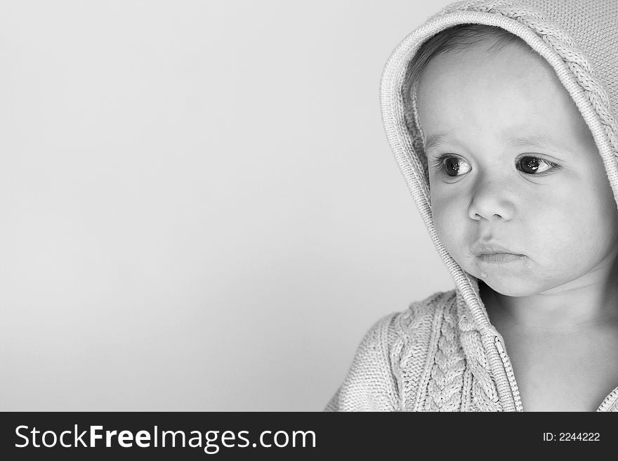 Black and white image of cute baby wearing a hooded sweater. Black and white image of cute baby wearing a hooded sweater