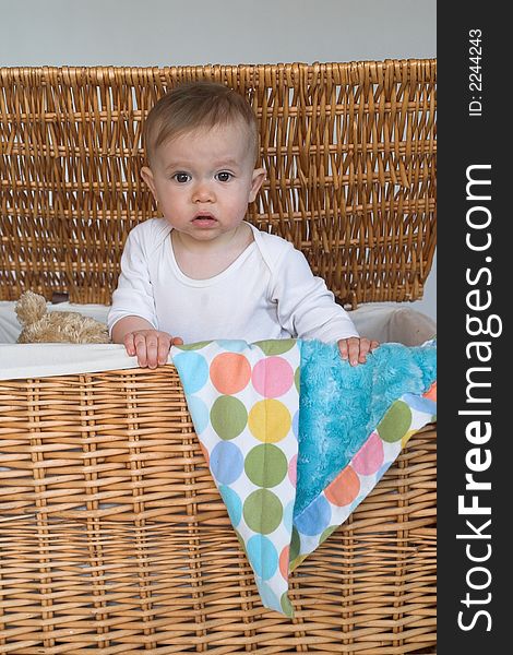 Image of a cute baby peeking out of a wicker trunk. Image of a cute baby peeking out of a wicker trunk