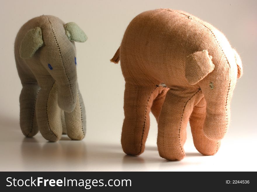 Small stuffed elephants isolated on white background following each other. Small stuffed elephants isolated on white background following each other
