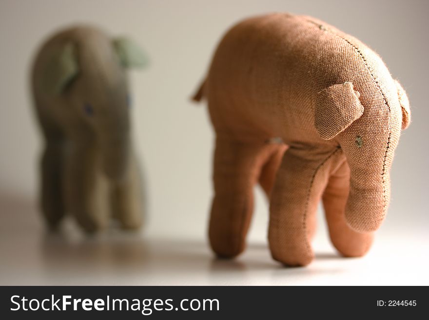 Small stuffed elephants isolated on white background following each other. Small stuffed elephants isolated on white background following each other