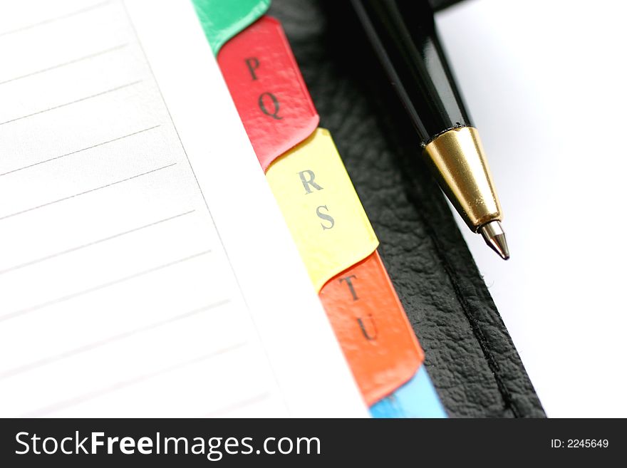 Address book with alphabet and pen closeup