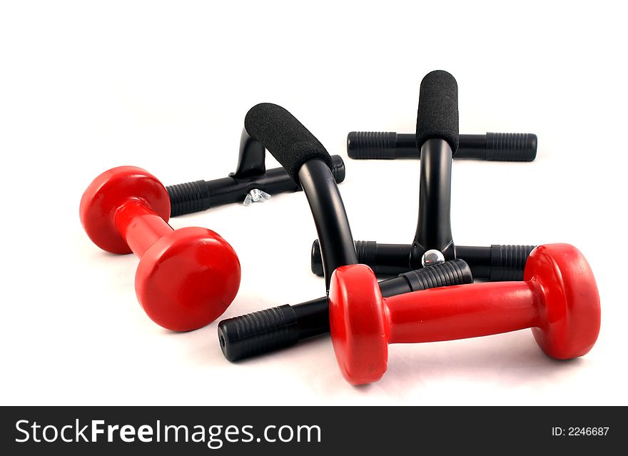 A set of weight training Dumbbells and press up Bars on a white background