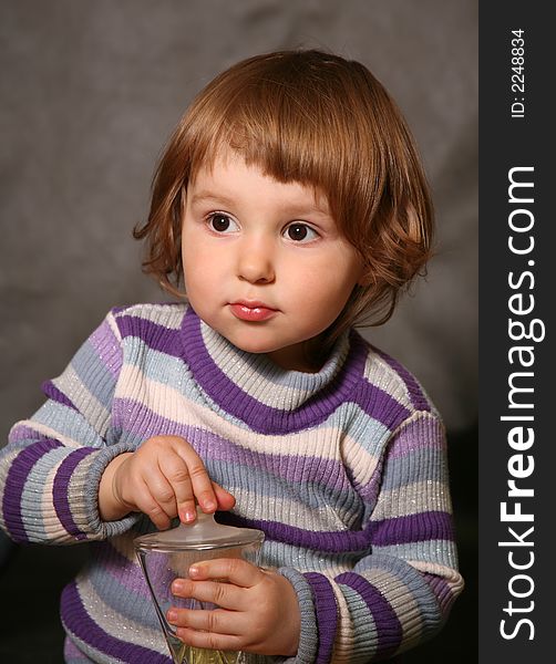 Portrait of the two-year-old girl with a bottle in hands. Portrait of the two-year-old girl with a bottle in hands