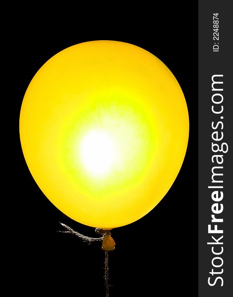 Yellow balloon on a string backlight isolated on black. Yellow balloon on a string backlight isolated on black