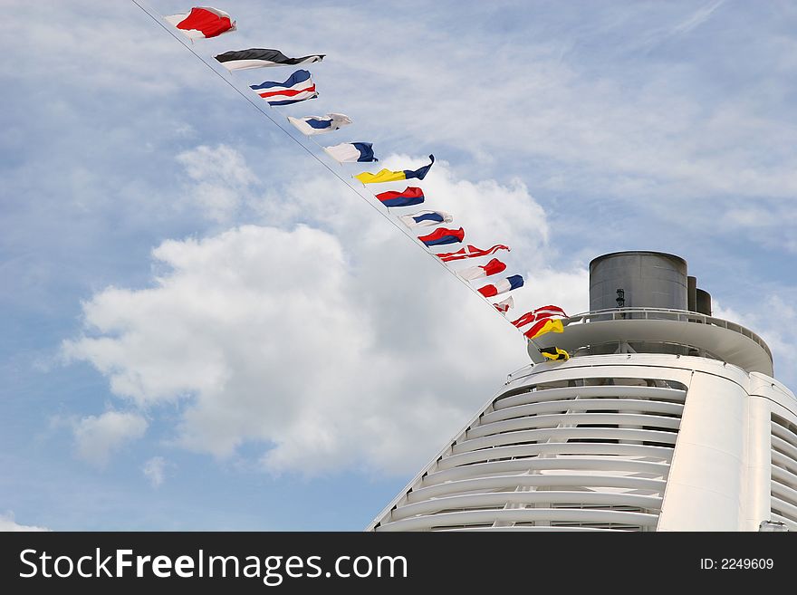 A ships smokestack and nautical flags against sky. A ships smokestack and nautical flags against sky