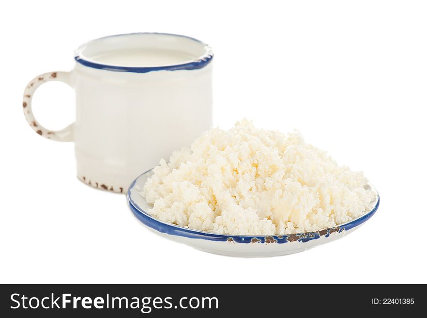 Cottage cheese and milk for breakfast in vintage dishware isolated on white background. Focus on plate