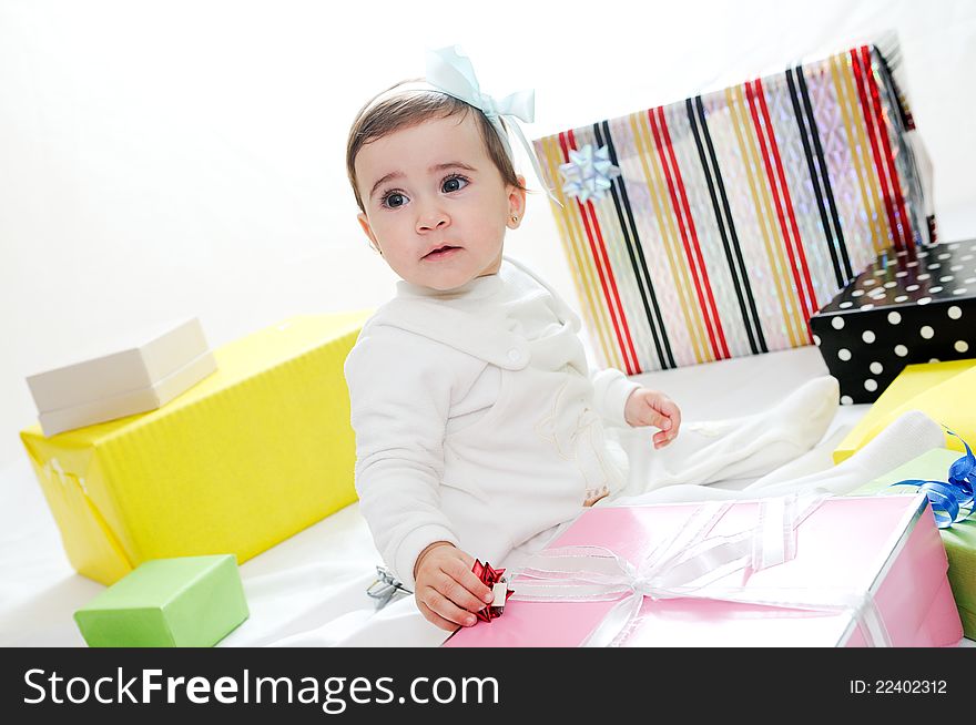 Nine months baby girl with gifts. Isolated on white background