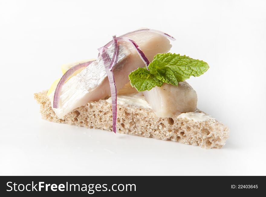 Sandwiches of rye bread with herring, onions and herbs.