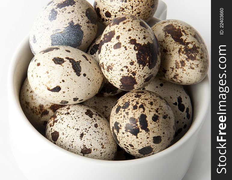 The quail eggs in bowl on white background