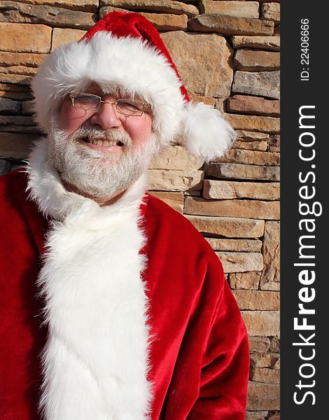 Santa Claus standing against a stone wall. Santa Claus standing against a stone wall.