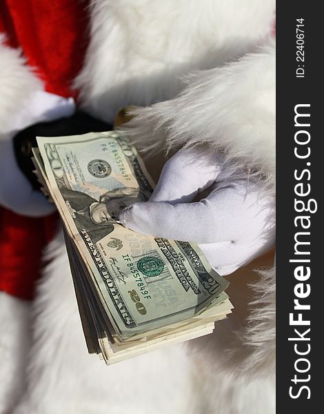 Santa Claus holding a stack of cash in his gloved hand. Santa Claus holding a stack of cash in his gloved hand.