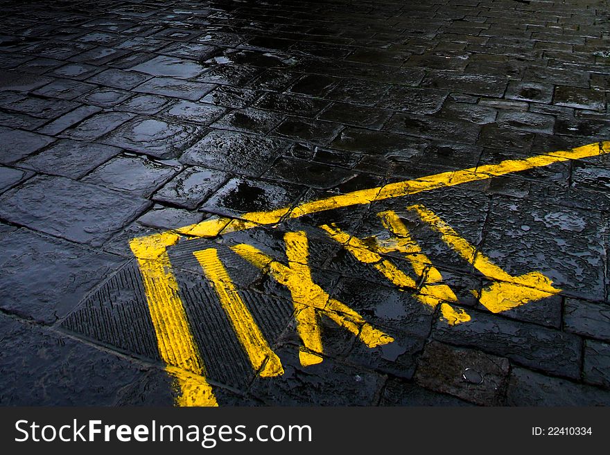 Taxi sign in rainy wather conditions on cobblestone street. Taxi sign in rainy wather conditions on cobblestone street