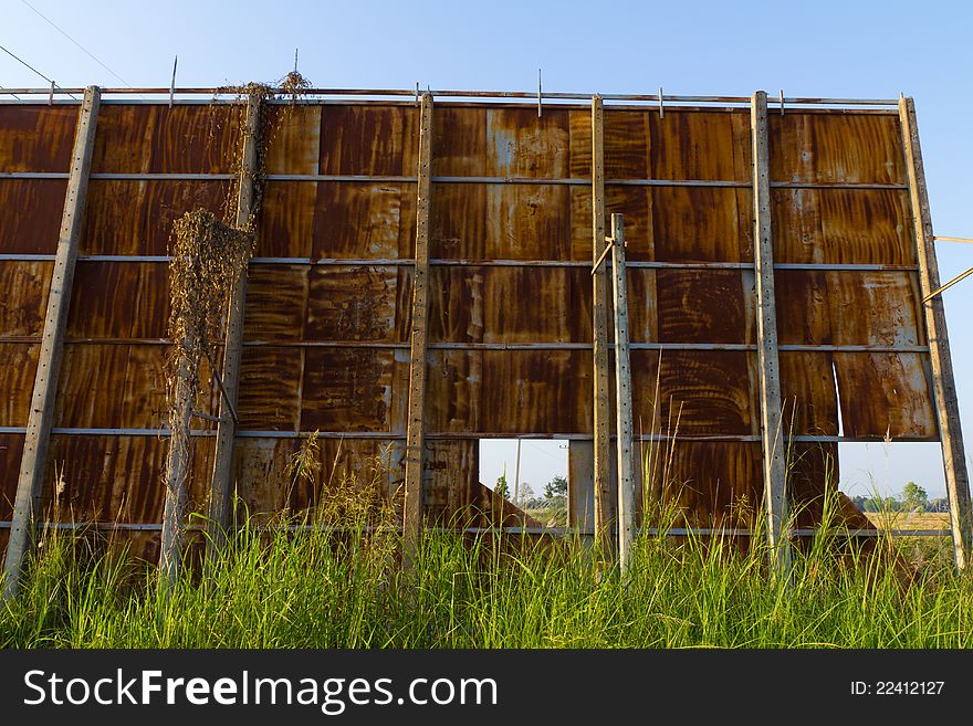 Huge rusty billboard in grass field
