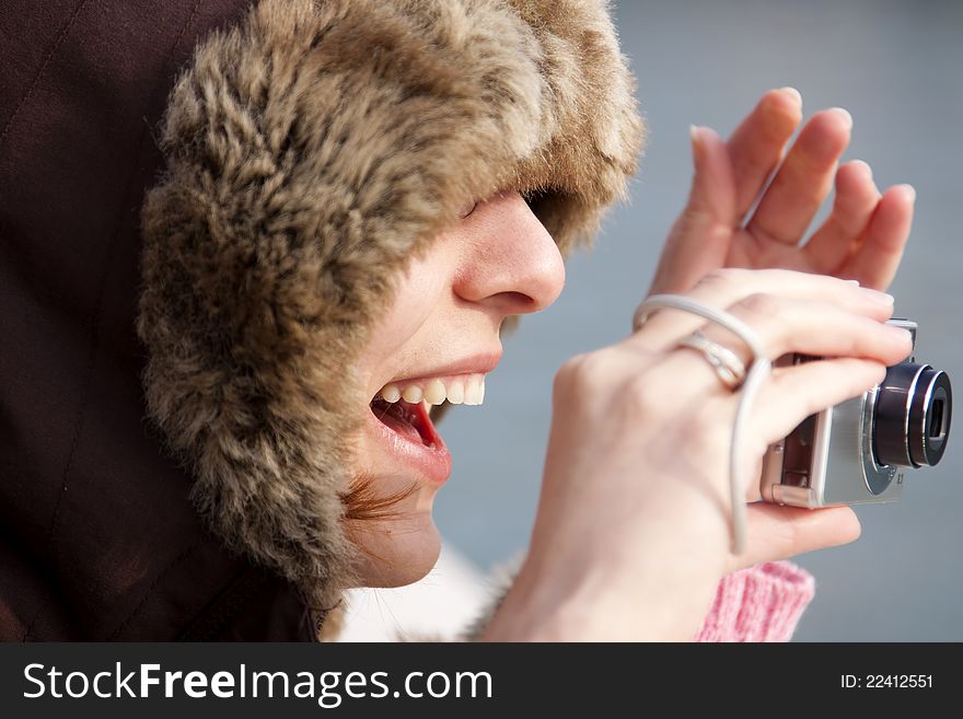 Happy woman taking pictures with compact camera