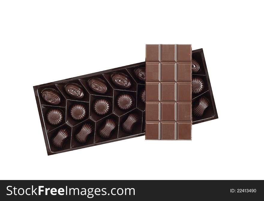 Bar of chocolate on box with candies on white background. Isolated with clipping path. Bar of chocolate on box with candies on white background. Isolated with clipping path