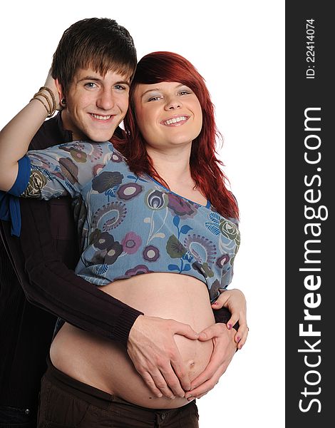 Young Couple Expecting with hands on her belly in a hart's shape on a white background