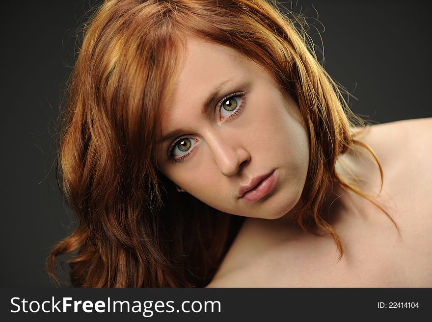 Portrait of Young Red Hair Woman isolated on a dark and neutral background