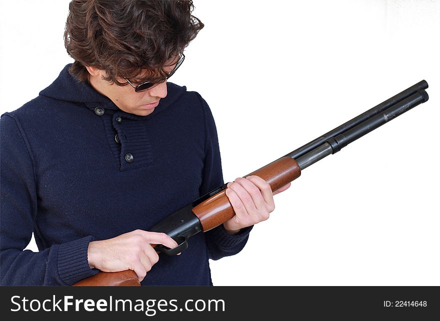 Young man with a shotgun is checking for bullets isolated