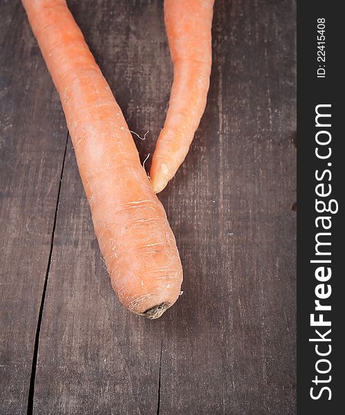 Two fresh carrots on plank