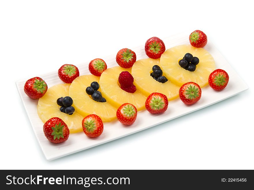 Pineapple slices with berries on white background