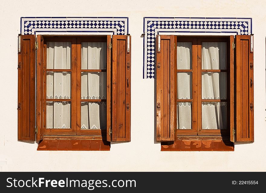 Windows with wooden shutters in the Spanish coastal town. Windows with wooden shutters in the Spanish coastal town.