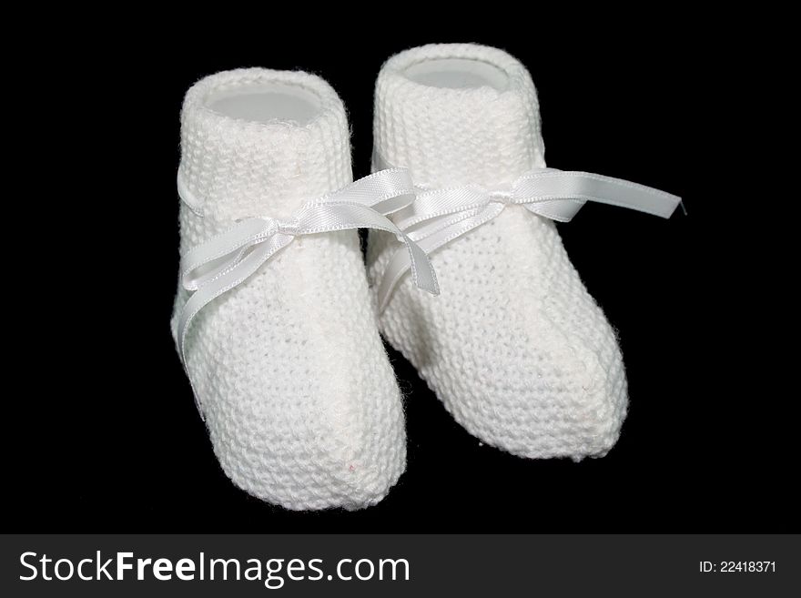 White baby socks with horizontal ties with black background. White baby socks with horizontal ties with black background