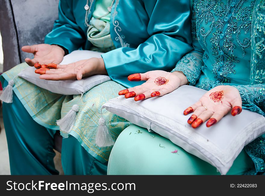 Bride's hands decorated with henna and groom's hands next to her's