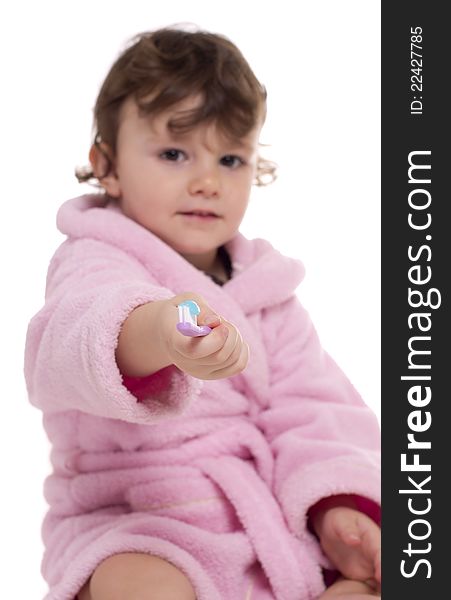 Three years old girl in pink dressing gown/bathrobe proposing to viewer her tooth brush. Three years old girl in pink dressing gown/bathrobe proposing to viewer her tooth brush.