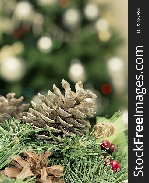 Christmas decoration: fir sprig,cones and blurry light from Christmas tree