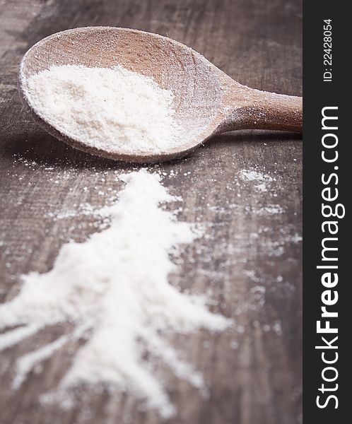 Close up photo of flour in a wooden spoon