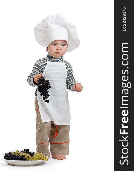 Child as chef with green and black grape over white background. Child as chef with green and black grape over white background