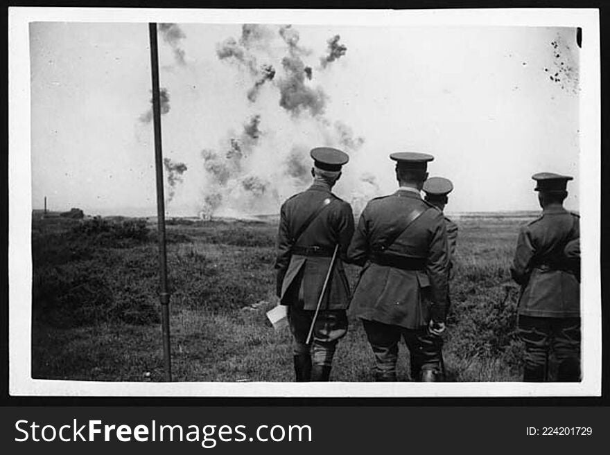 King George V and his entourage watching a trench mortar bombardment. They are all in uniform and are standing with their backs to the camera. The King is most likely the figure standing in front, furthest from the camera. The group are standing on a grassy plain and are watching the distant bombardment. 

Members of royalty touring the Western Front were kept well behind the front line, away from any active fighting. Visits, however, were sometimes made to newly captured and secure areas of the Front. There are images in this collection of King George V visiting a number of battlefields, after the event.

[Original reads: &#x27;THE KING VISITS THE WESTERN FRONT. H.M. watching a trench mortar bombardment.&#x27;]

digital.nls.uk/74547136