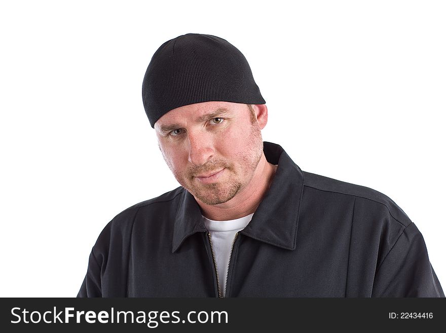 An angry looking man with a black coat and beanie hat