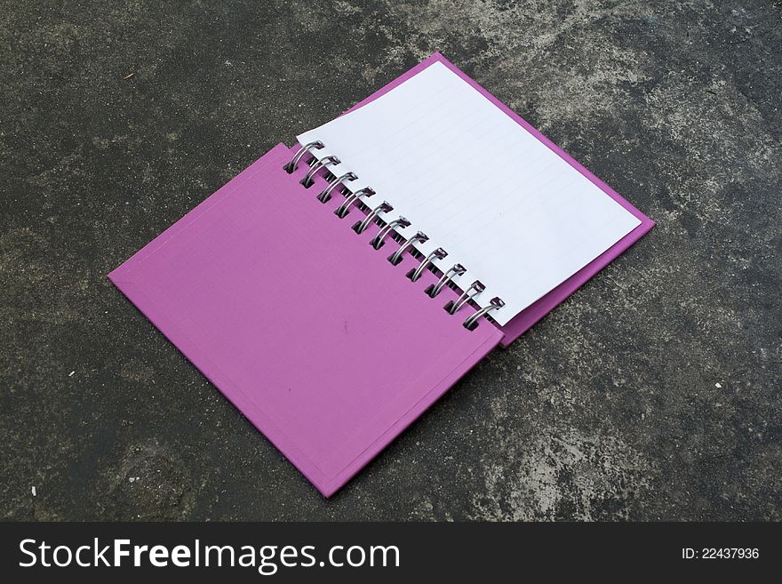 Open pink book on Concrete