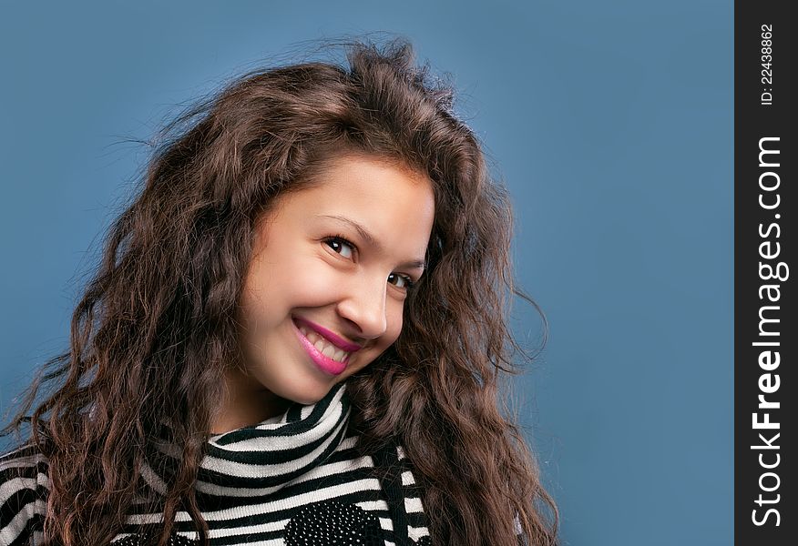 Portrait of beautiful smiling girl isolated on blue background