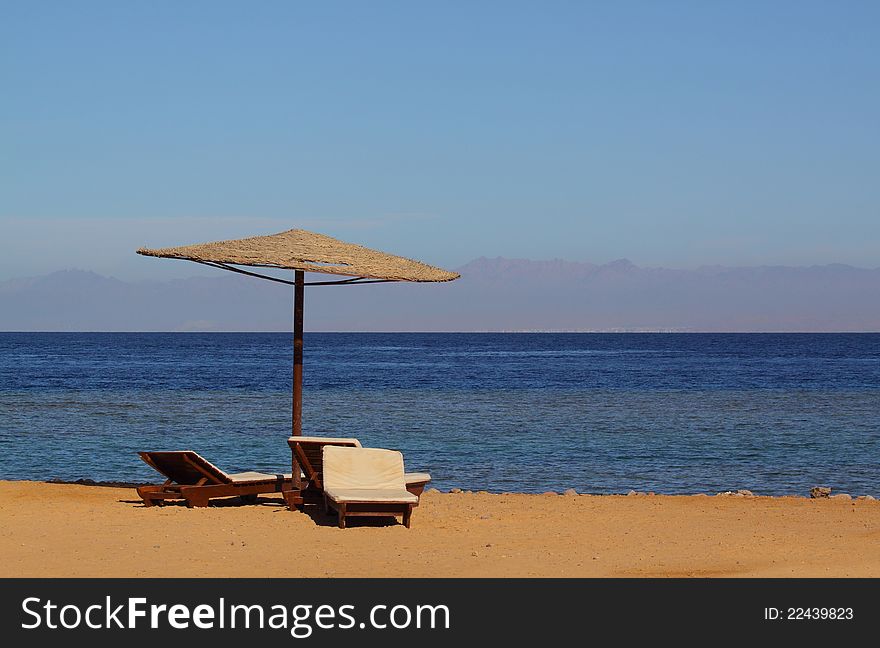 Sunshade and sun loungers on the Red Sea shore. Sunshade and sun loungers on the Red Sea shore