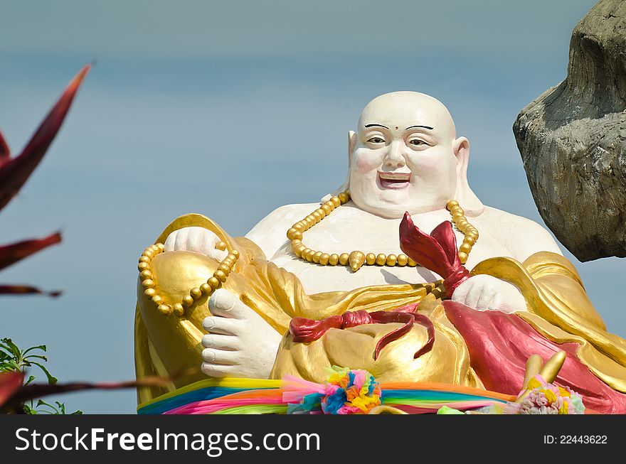 Smiling Buddha Statue with blue sky