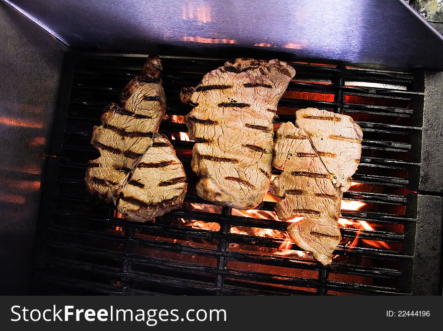 Raw meat steaks on a fire bbq grill. Raw meat steaks on a fire bbq grill