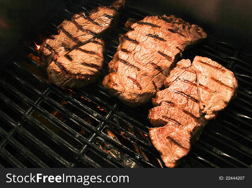 Raw meat steaks on a fire bbq grill. Raw meat steaks on a fire bbq grill